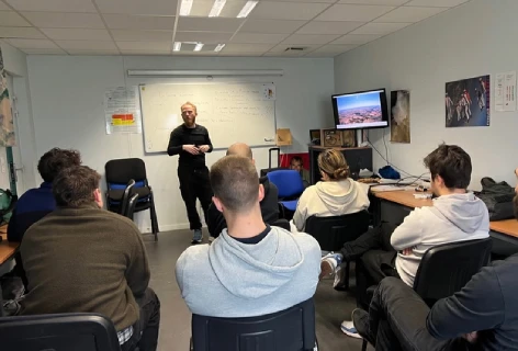 Moniteur fédéral dispensant la formation théorique à plusieurs élèves en salle de cours.