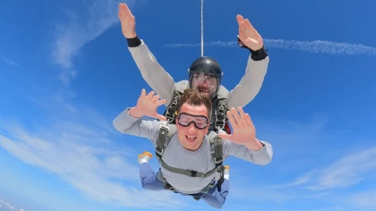 Passager harnaché à son moniteur en chute libre lors d'un saut en tandem